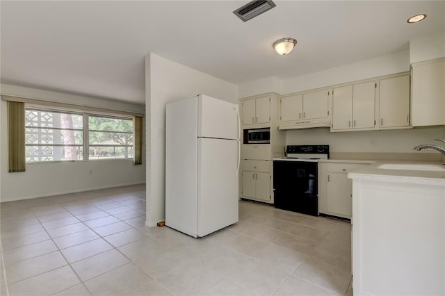 kitchen featuring light tile patterned flooring, white appliances, and sink