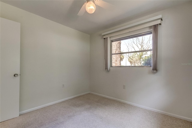 carpeted spare room featuring ceiling fan