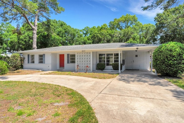 ranch-style home featuring a front lawn and a carport