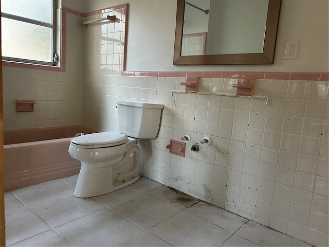 bathroom with tile patterned flooring, tile walls, and toilet