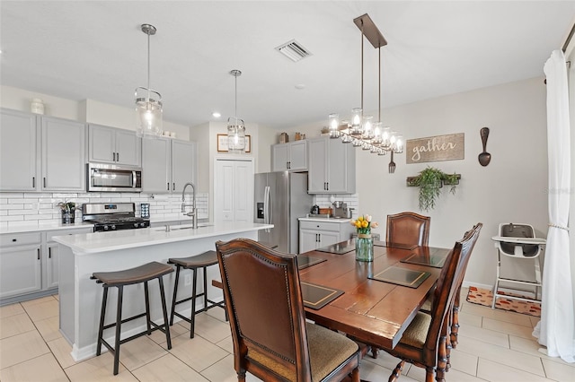 dining space featuring sink and light tile patterned floors