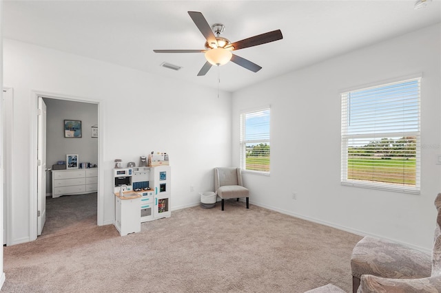 sitting room featuring ceiling fan and light carpet