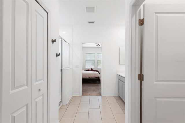 hall with light colored carpet