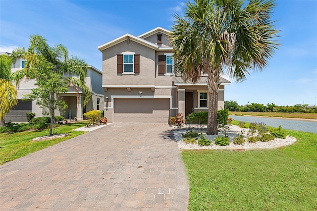 view of front of home with a water view, a front lawn, and a garage