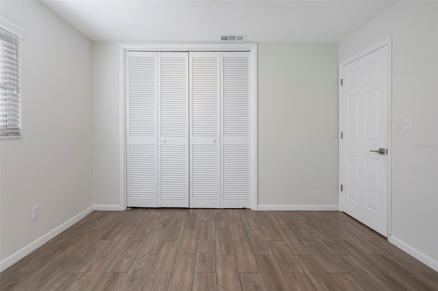 unfurnished bedroom featuring hardwood / wood-style flooring and a closet