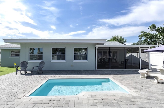 back of property with a fenced in pool, a sunroom, and a patio