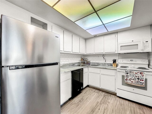 kitchen featuring white appliances, white cabinets, sink, light hardwood / wood-style flooring, and tasteful backsplash