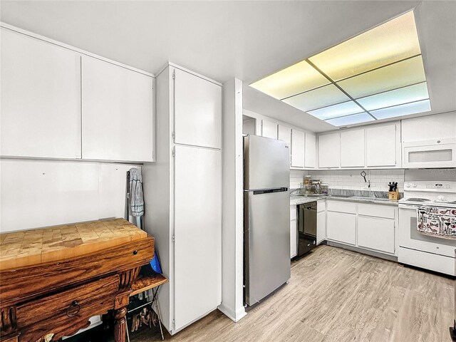 kitchen featuring white cabinets, decorative backsplash, light hardwood / wood-style floors, and white appliances