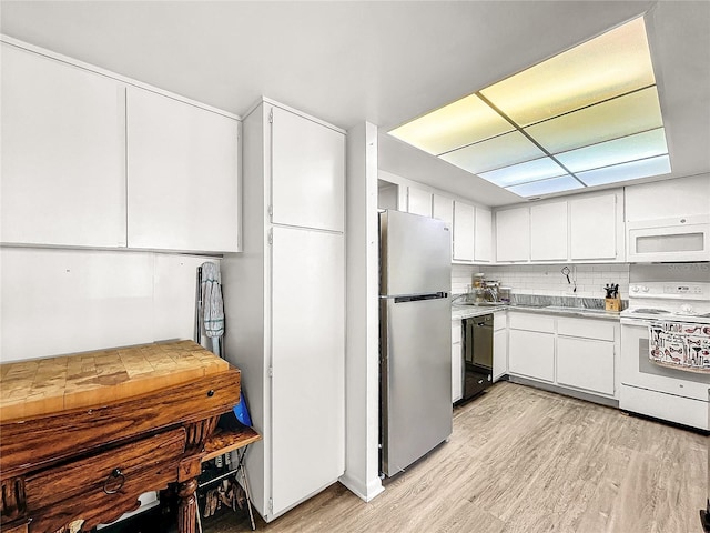 kitchen with tasteful backsplash, white cabinets, white appliances, and light hardwood / wood-style floors