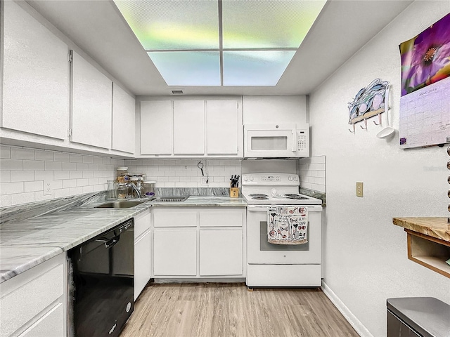 kitchen with white appliances, light hardwood / wood-style floors, white cabinetry, and backsplash