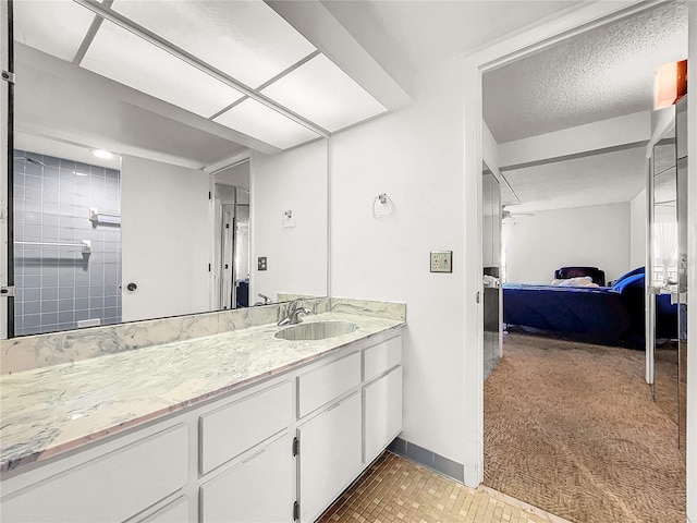 bathroom featuring vanity, a shower, and a textured ceiling