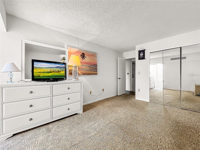 unfurnished bedroom with light carpet, a closet, and a textured ceiling