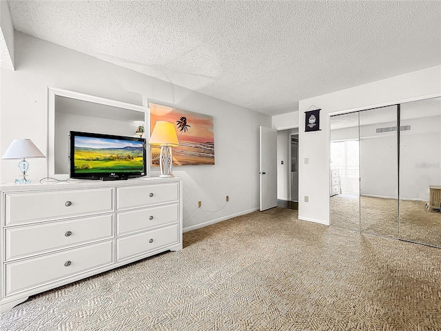 unfurnished bedroom featuring light carpet, a textured ceiling, and a closet