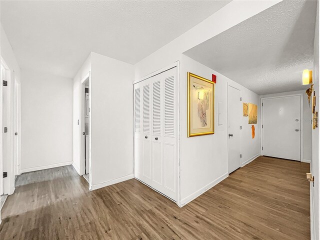 hallway featuring a textured ceiling and hardwood / wood-style flooring