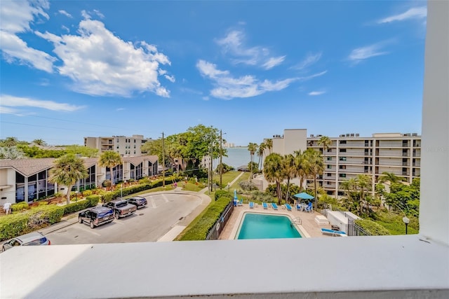 view of swimming pool with a water view and a patio