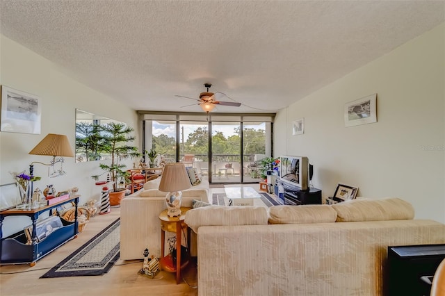 living room with hardwood / wood-style flooring, ceiling fan, floor to ceiling windows, and a textured ceiling