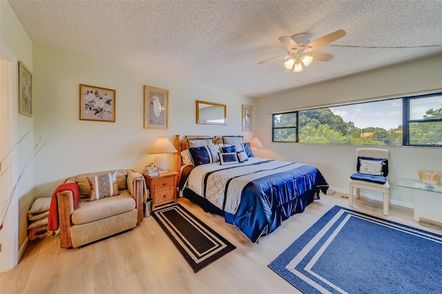 bedroom with ceiling fan, a textured ceiling, and hardwood / wood-style flooring