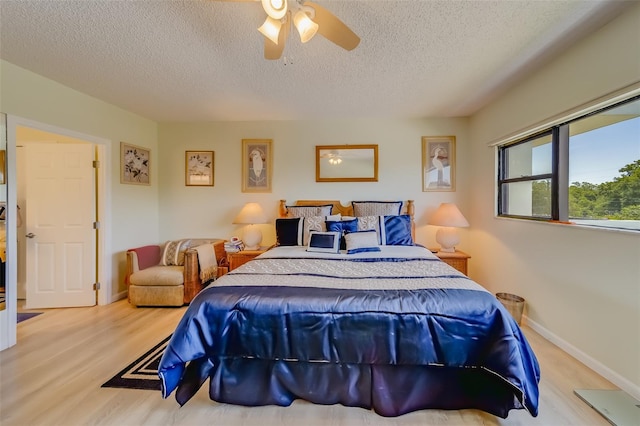 bedroom featuring a textured ceiling, light wood-type flooring, and ceiling fan