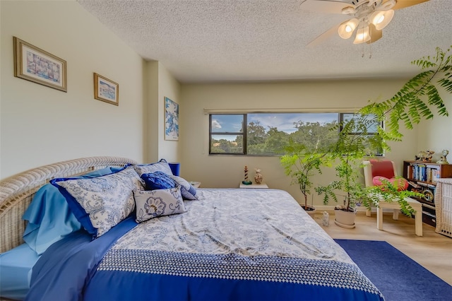 bedroom featuring hardwood / wood-style floors, ceiling fan, and a textured ceiling