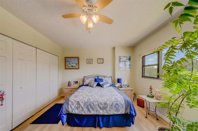 bedroom with ceiling fan, light wood-type flooring, a textured ceiling, and a closet