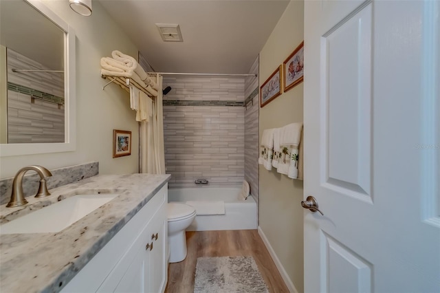 full bathroom with hardwood / wood-style flooring, toilet, vanity, and tiled shower / bath