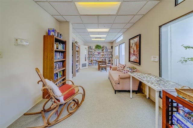 sitting room with carpet flooring and a paneled ceiling