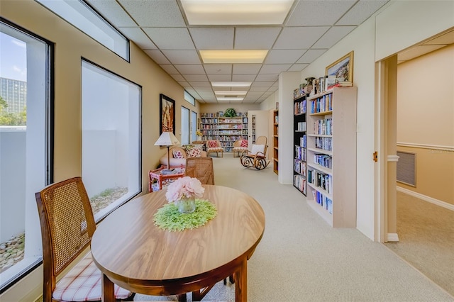 carpeted dining space featuring a paneled ceiling