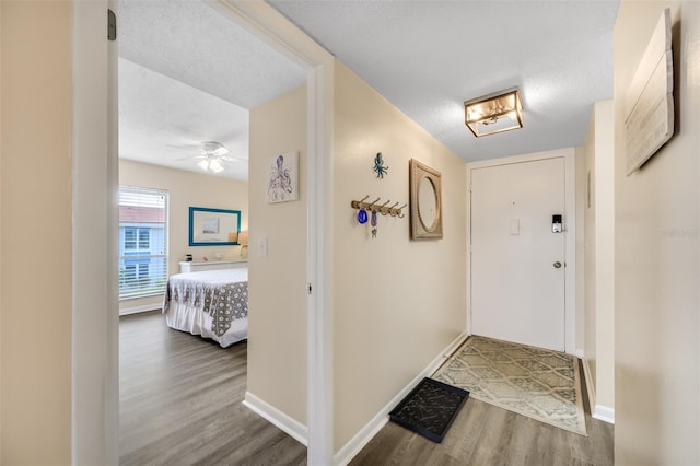 entrance foyer featuring a textured ceiling, dark hardwood / wood-style flooring, and ceiling fan