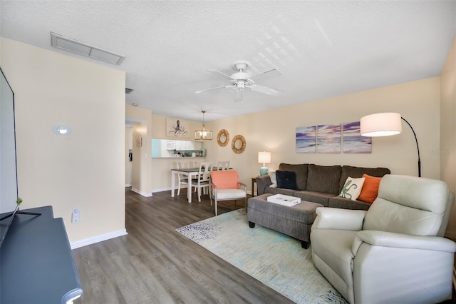 living room featuring ceiling fan, wood-type flooring, and a textured ceiling