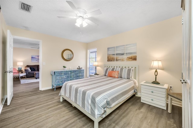 bedroom featuring hardwood / wood-style flooring, ceiling fan, and a textured ceiling