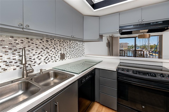 kitchen featuring black appliances, decorative backsplash, sink, light hardwood / wood-style floors, and gray cabinetry