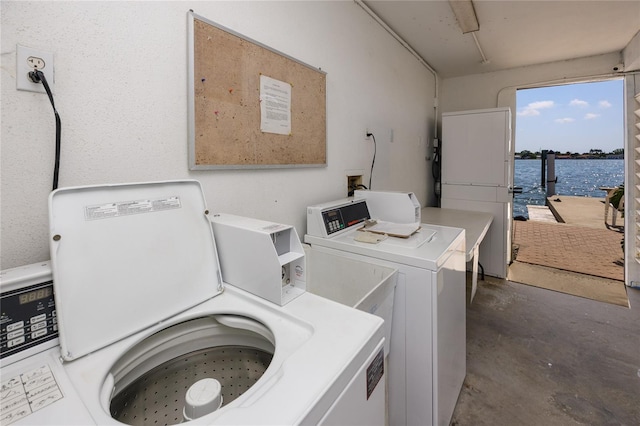 washroom with separate washer and dryer and a water view