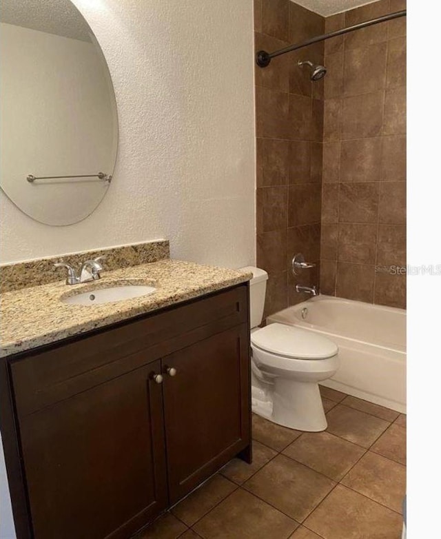 full bathroom with toilet, vanity, tile patterned floors, and tiled shower / bath