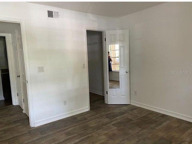 unfurnished room featuring a textured ceiling and dark wood-type flooring