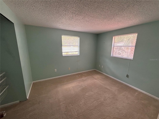 carpeted spare room featuring a textured ceiling