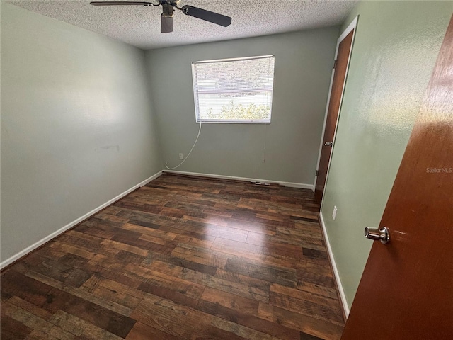 spare room with a textured ceiling, ceiling fan, and dark wood-type flooring