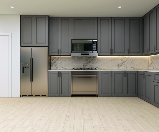 kitchen featuring gray cabinets, decorative backsplash, light wood-type flooring, and appliances with stainless steel finishes