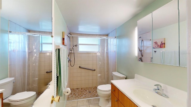 bathroom featuring vanity, a healthy amount of sunlight, toilet, and a tile shower