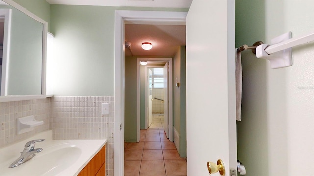 bathroom with tile patterned floors, vanity, and tile walls