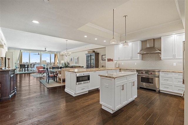 kitchen with wall chimney exhaust hood, stainless steel range, pendant lighting, white cabinets, and a center island