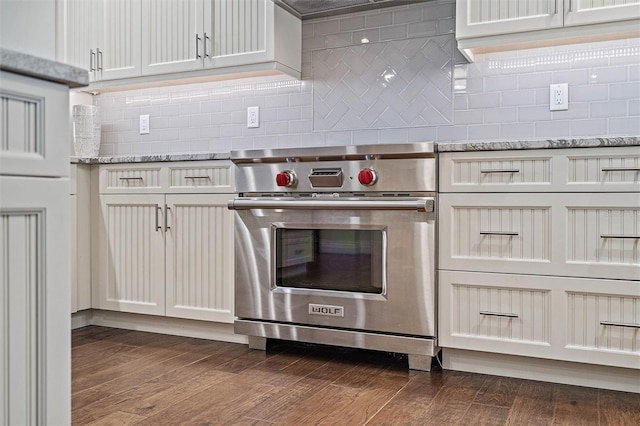 kitchen featuring backsplash, light stone counters, high end stainless steel range, and dark wood-type flooring