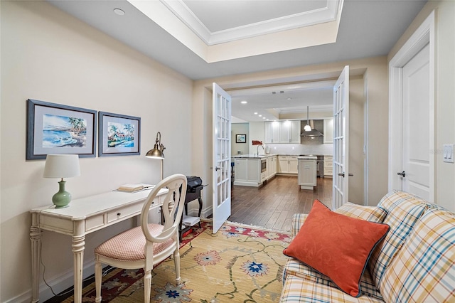 office space featuring a tray ceiling, crown molding, french doors, and hardwood / wood-style flooring