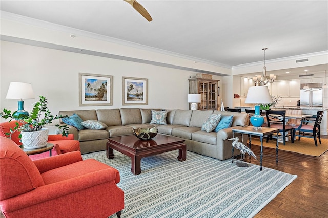 living room with hardwood / wood-style flooring, a chandelier, and ornamental molding