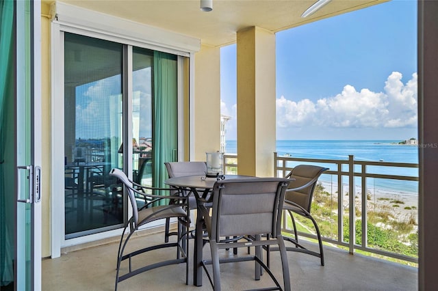 balcony with a water view and a view of the beach