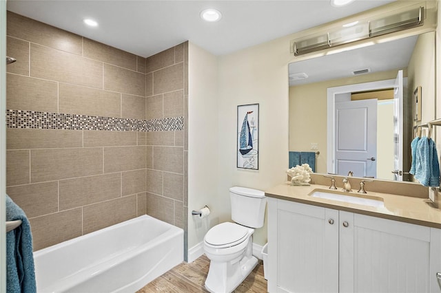 full bathroom with hardwood / wood-style floors, vanity, toilet, and tiled shower / bath combo