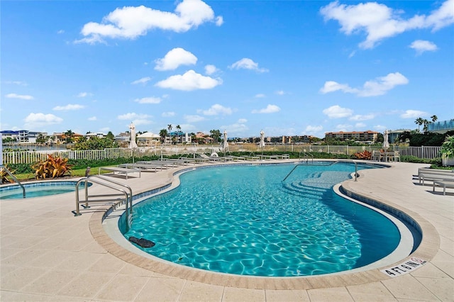 view of swimming pool featuring a patio area and a hot tub