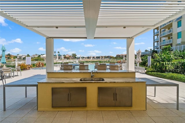 view of patio featuring a pergola, sink, and a pool