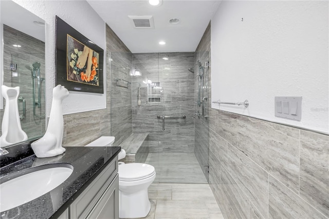 bathroom featuring toilet, tile walls, walk in shower, and vanity