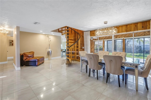 dining space with a wealth of natural light, wooden walls, and a chandelier