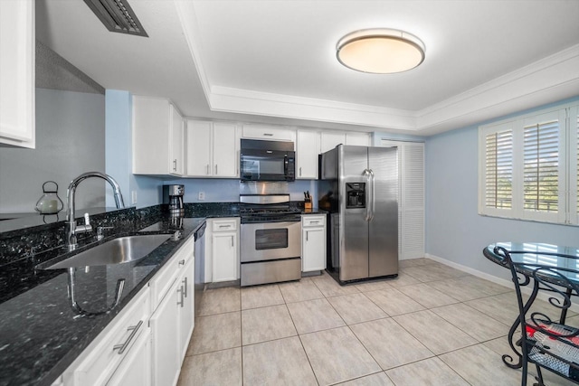 kitchen featuring stainless steel appliances, white cabinetry, a tray ceiling, and sink